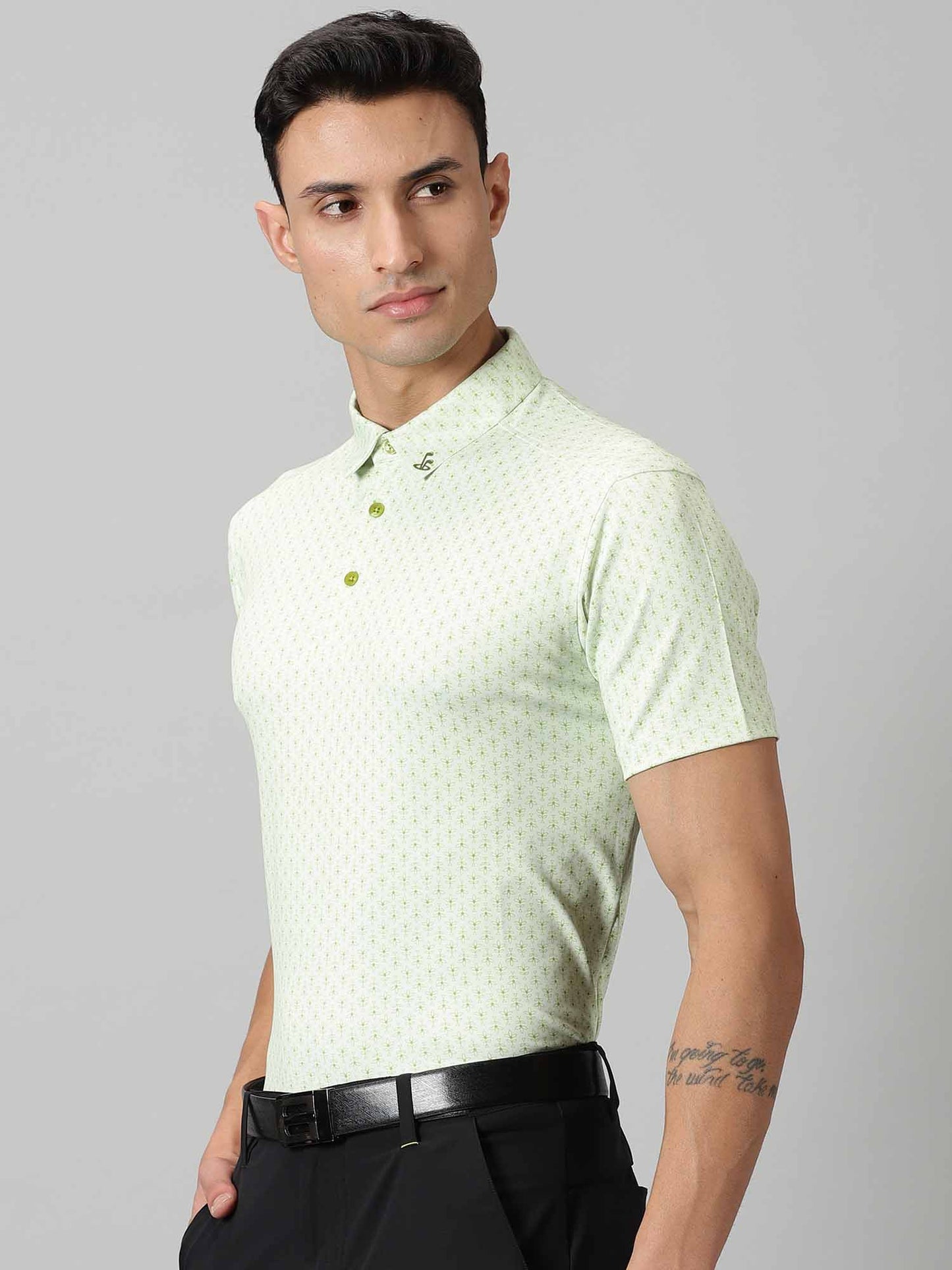 Image of All-over printed short sleeved polo with abstract plants in green, features a handmade collar. The yoke sports contrasting colour with silicon detailing on the collar tip and back. From Firstcut.co