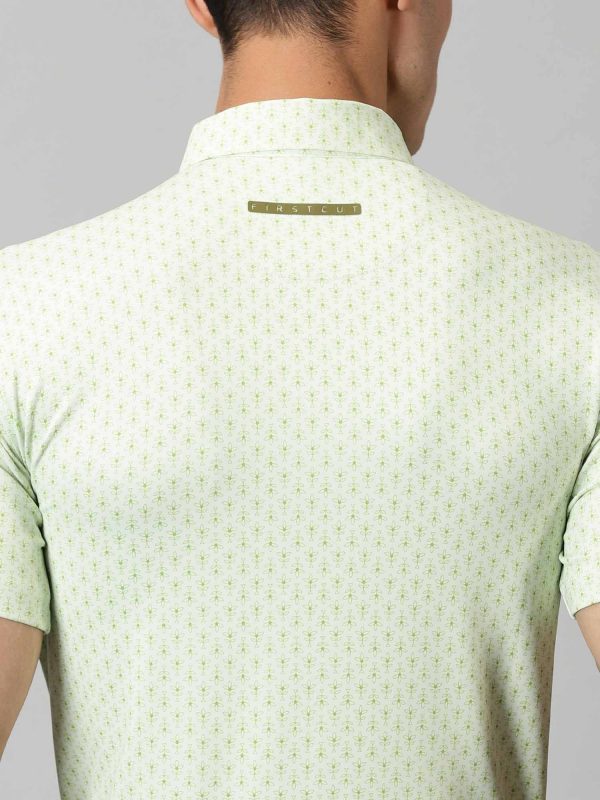 Image of All-over printed short sleeved polo with abstract plants in green, features a handmade collar. The yoke sports contrasting colour with silicon detailing on the collar tip and back. From Firstcut.co