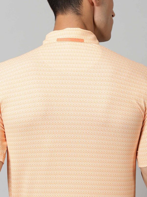 Image of All-over printed short sleeved polo sports geometric patterns in sorbet and exotic orange complete with a handmade collar. The silicon detailing adorns the front and back. From Firstcut.co